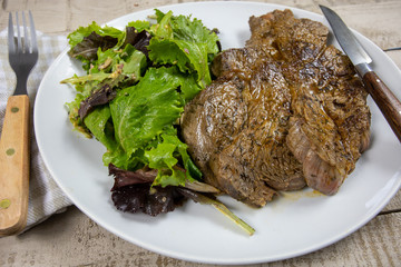 grilled prime rib and salad on a plate