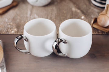 Close up of white mugs of hot drinks. Copy space. New Year eve concept