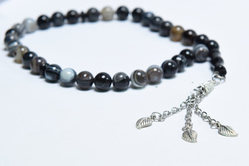 Handmade rosary necklace made of beads, black agate and silver on white Background	