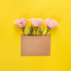 Eustoma flower arrangement with flowers and blank card, on yellow background