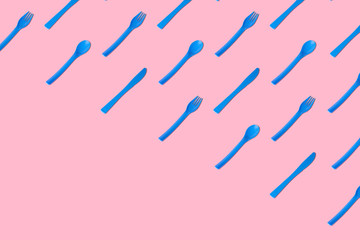 Blue cutlery on rose background abstract.