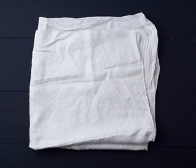 folded white linen towel on blue wooden background