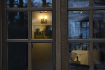 Drown wooden window. light through a wooden window. wall lamp on the wall.
