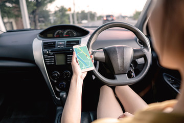 Naklejka premium Woman in the car and holding mobile phone with map gps navigation