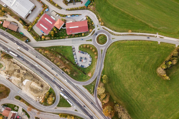 Top down aerial view of freeway interstate road with moving traffic cars in rural area.