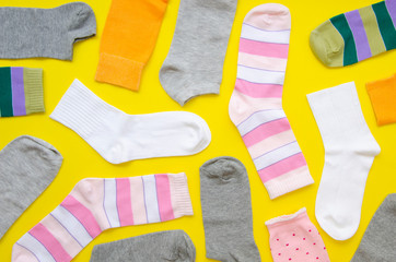 Flat lay colorful socks on yellow background