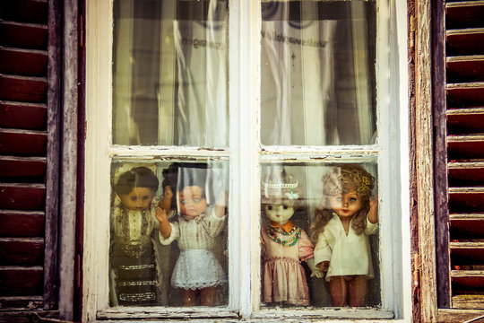Horror dolls over the window sill 