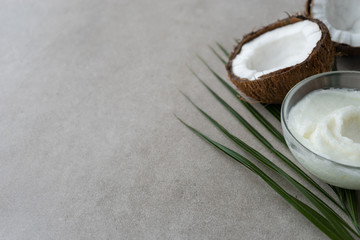 image of half coconuts , coconut oil and palm leaf