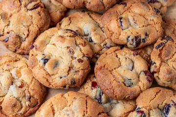 Homemade cookies with cranberries and chocolate top on bakery paper