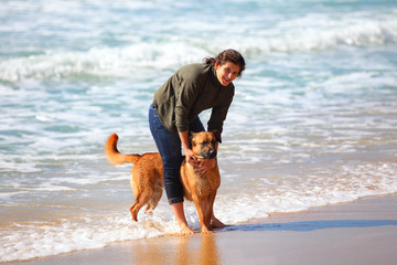Teenage girl with her dog on the beach.