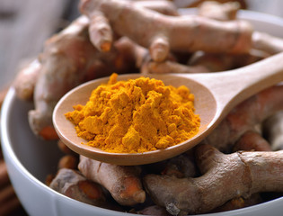 turmeric powder in wooden spoon