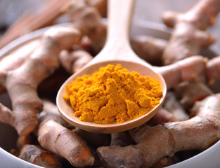 turmeric powder in wooden spoon