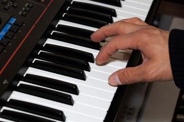 Hands on the piano keyboard electronic organ close-up. Hands of musician play on the piano.