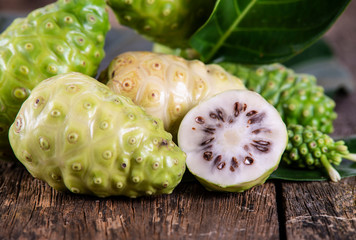 Noni fruit on wooden table