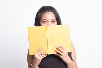 Young Asian woman with a book cover her face.