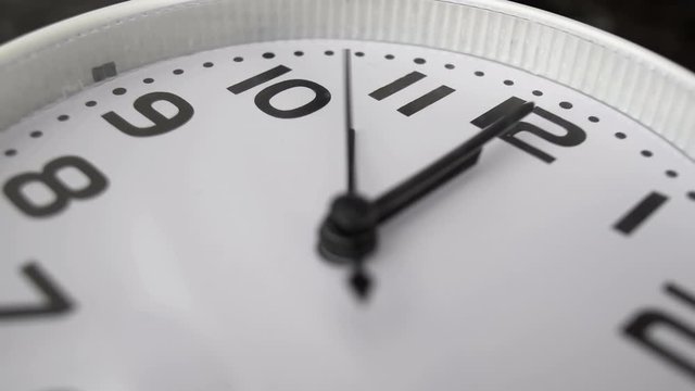white clock hanging on wall ticking shows twelve o&rsquo;clock