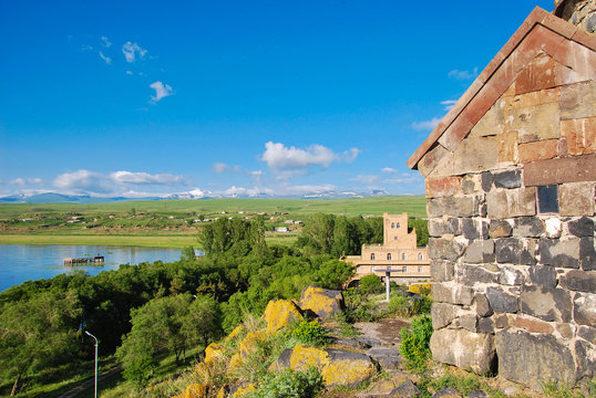 Beautiful view of Sevan lake with turquoise water and green hills, Sevan, Armenia. nature of Armenia. Lake Sevan. Sevan lake coastline with houses and trees. lake and white clouds on blue sky
