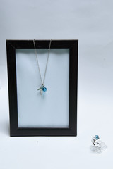 Beautiful necklace and blue gemstone pendant with ring decorated by silver in shape of Dolphin fins