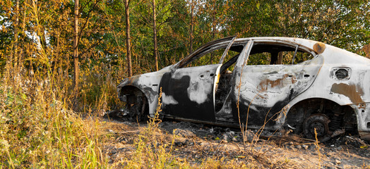 Burnt out car, closeup. Inside a burnt auto.Melted glass due to high temperatures, ashes and a burnt car interior.Abandoned car in the forest near the city. The concept of a traffic accident. 