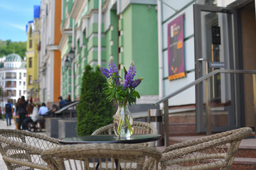 Fototapeta na wymiar a bouquet of purple lupins on the table in the cafe