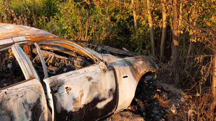 Burnt out car, closeup. Inside a burnt auto.Melted glass due to high temperatures, ashes and a burnt car interior.Abandoned car in the forest near the city. The concept of a traffic accident. 