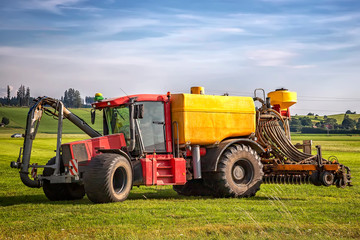 Obraz na płótnie Canvas heavy tractor for application of manure on arable farmland at the field in Germany