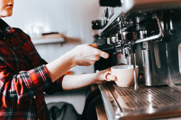 Barista makes aromatic coffee. Process of making latte coffee on a coffee machine in a cafe