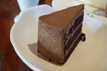 Chocolate cake, cheesecake with strawberry jam and hot chocolate beverage in a cafe.