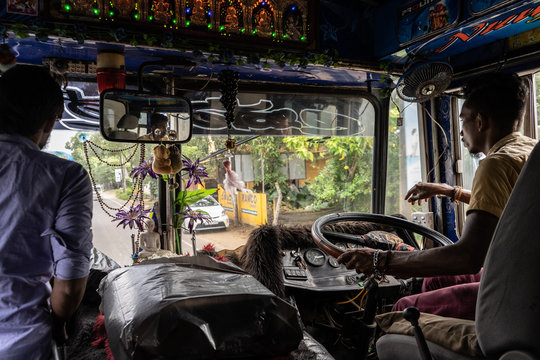 Hikkaduwa, Sri Lanka, November, 2019: Bus driver and ticket conductor ride a typical Sri Lankan bus