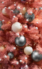 Obraz na płótnie Canvas Pink Christmas tree.Pink Xmas tree.A creative, festive Christmas tree stands in the building, lush branches are decorated with white and gray plastic balls,and small garlands that illuminate the tree.