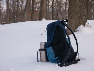 backpack and thermos in the snow
