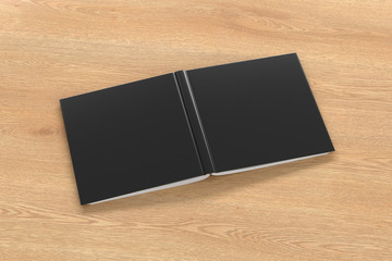Blank black square open and upside down book cover on wooden background isolated with clipping path around cover. 3d illustration