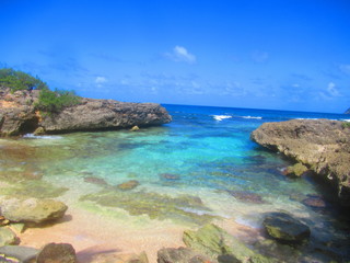 Fototapeta na wymiar La mer turquoise sous un ciel bleu avec une petite plage