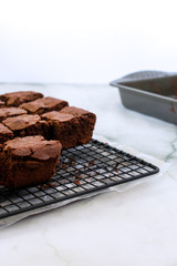 Close vertical view of homemade stacked brownies on cooling rack over marbled background with copy space. High key