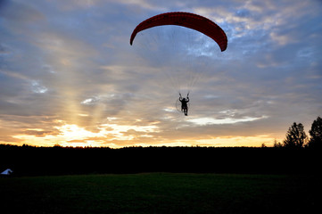 silhouette of paraglider at sunset
