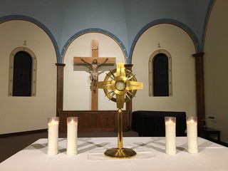 Crucifix with candles and exposed Eucharist in monstrance