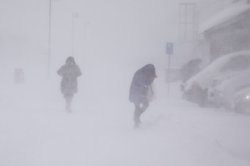 Blizzard in Longyearbyen . People in snowfall. Abstract blurry winter weather background