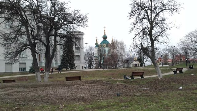 The panorama of Kiev in the area of the Andreevsky Church shows the St. Andrew's Church itself and part of the building of the historical museum, passers-by cyclist walks.