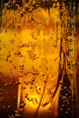 Beer in a glass with bubbles and a wheat spike. water drops. macro view. Pouring beer froth in glass for background. Close up.
