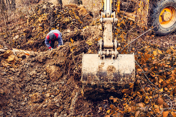 An excavator in the forest digs a ladle for fish breeding.