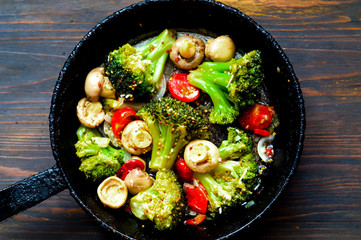 Vegetable mix mit Mushroom in authentic pan on wooden background. Healthy eating concept. Budget-friendly menu. Close-up