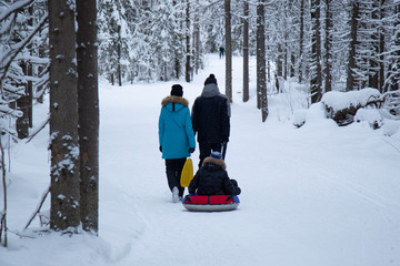 The family walks and rests in the Park in the winter on a day off.