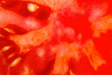 Food background. Slice of fresh red tomato. Detailed macro shot. Top view.