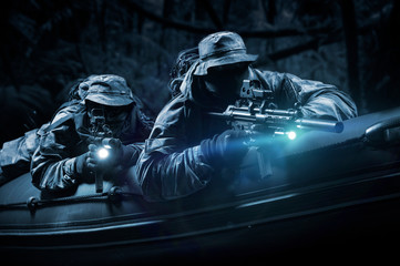 Two fighters of a special unit move through the forest at night. The concept of special operations,...