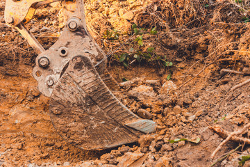 The excavator performs excavation work by digging the ground with a bucket in the forest.