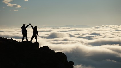 silhouette of climber on top of mountain