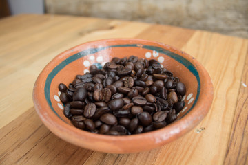 Granos de café en recipiente de barro