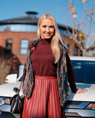 Beautiful blond woman at her white car, jeep, sport utility