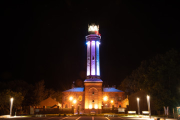 Universe filled with stars, nebula and galaxy. Lighthouse in Niechorze, Poland.