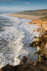 seascape, rocks and north beach with waves in the town of Nazare on the shores of the Atlantic Ocean. spring at evening
